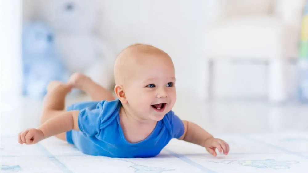 Bébé souriant allongé sur le ventre