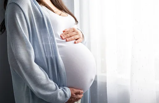 Femme enceinte, les mains posées sur son ventre