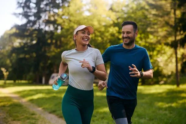 Deux coureurs souriants dans un parc